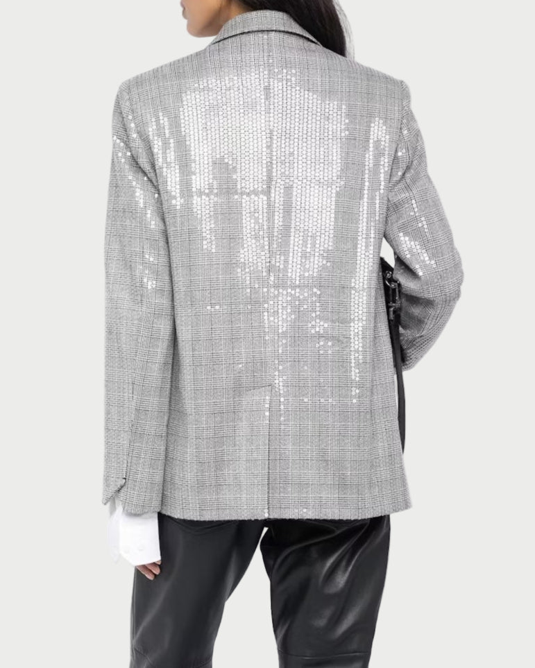 Person wearing a silver checkered blazer and black leather pants on a white background