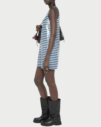Woman wearing a blue and white striped dress with black boots on a white background