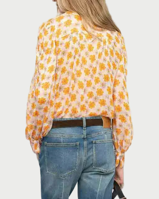 Woman wearing a yellow floral blouse and blue jeans on a white background