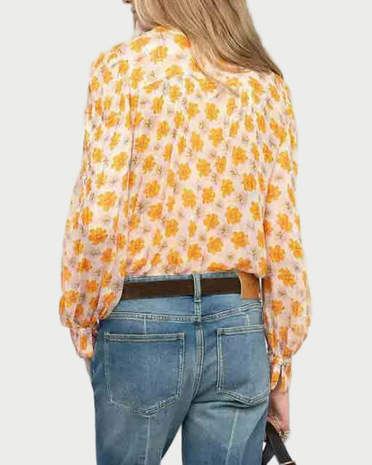 Woman wearing a yellow floral blouse and blue jeans on a white background