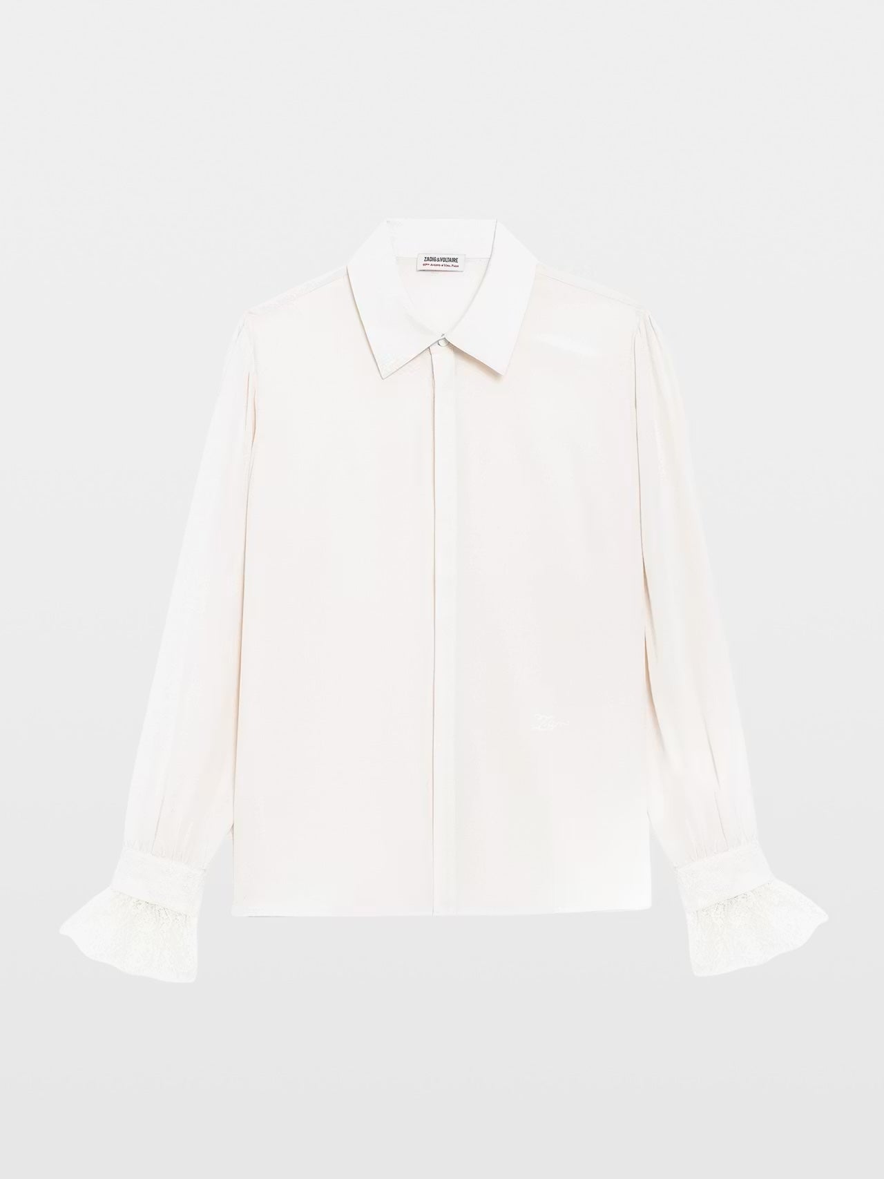 A long-sleeve white button-up blouse with a pointed collar and ruffled cuffs, displayed flat against a light gray background.