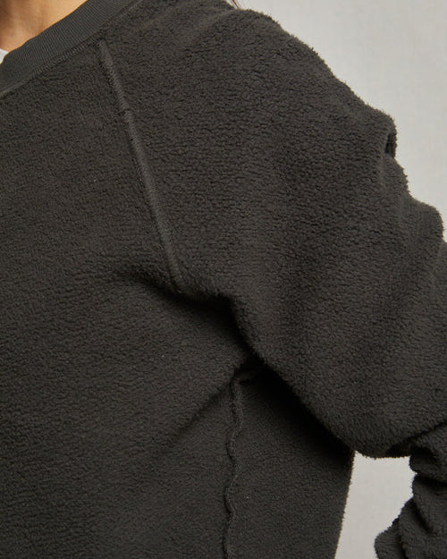 Close-up of a dark gray fleece jacket on a neutral background