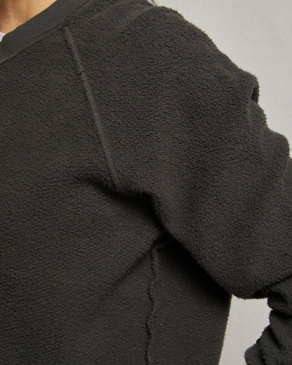 Close-up of a dark gray fleece jacket on a neutral background