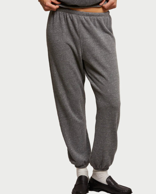 Person wearing gray sweatpants on a plain background