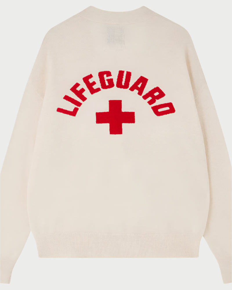 The JUMPER1234 Lifeguard Cardigan is a white cashmere V-neck featuring "LIFEGUARD" in red capitals and a red cross symbol on the back.