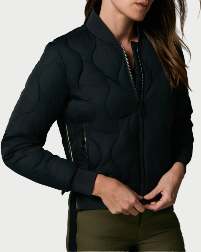 Woman wearing a black jacket against a gray background