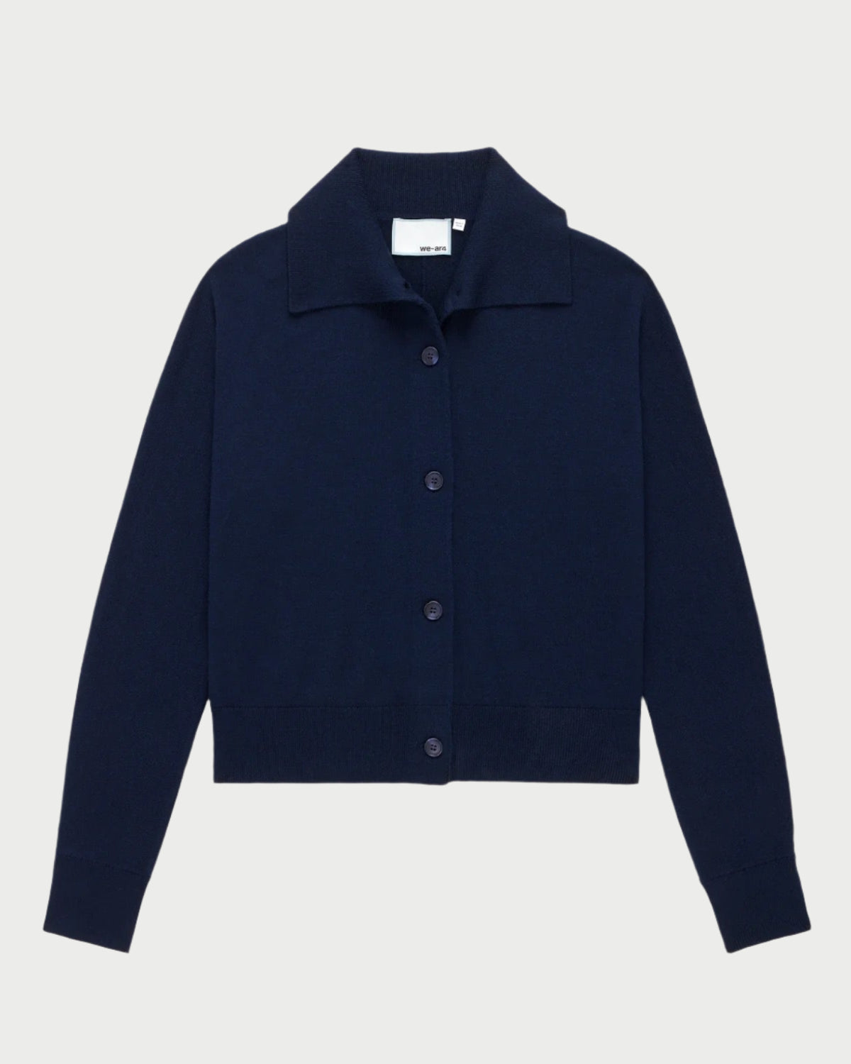 The Social Cardigan Navy by WE-AR4 is a dark blue button-up cardigan made from Merino Wool, featuring a collar and long sleeves, displayed on a plain white background.
