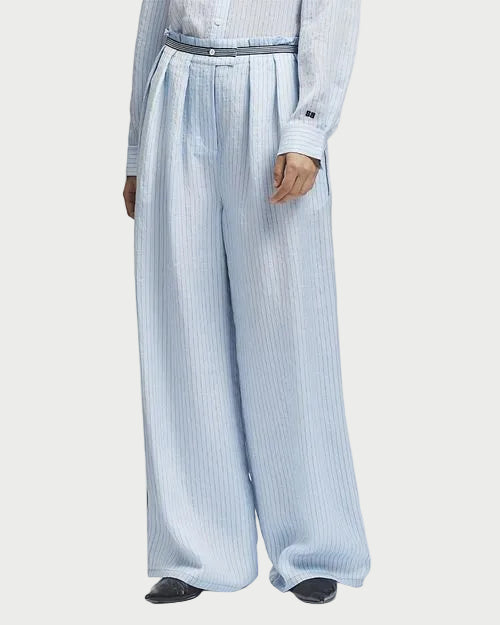 Person wearing light blue striped pants and a matching shirt on a white background