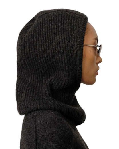 A person in profile, wearing glasses and the Herskind Cashmere Balaclava by Herskind, is set against a white background, highlighting this minimalist winter accessory.
