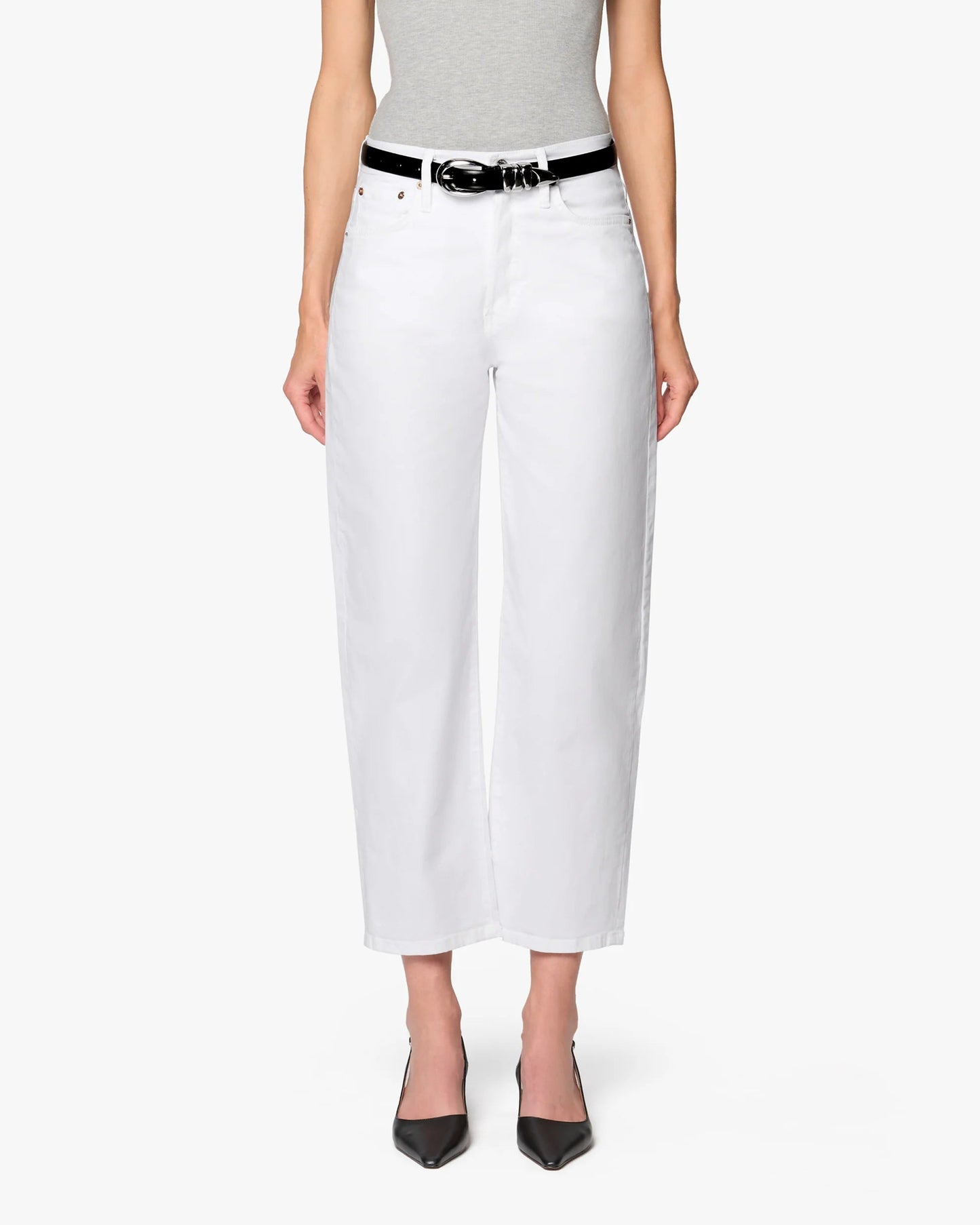 A person stands facing forward against a plain white background, wearing a gray sleeveless top, Betro Simone's Ellen Bow Leg Pant in white with a black belt, and black pointed-toe heels.