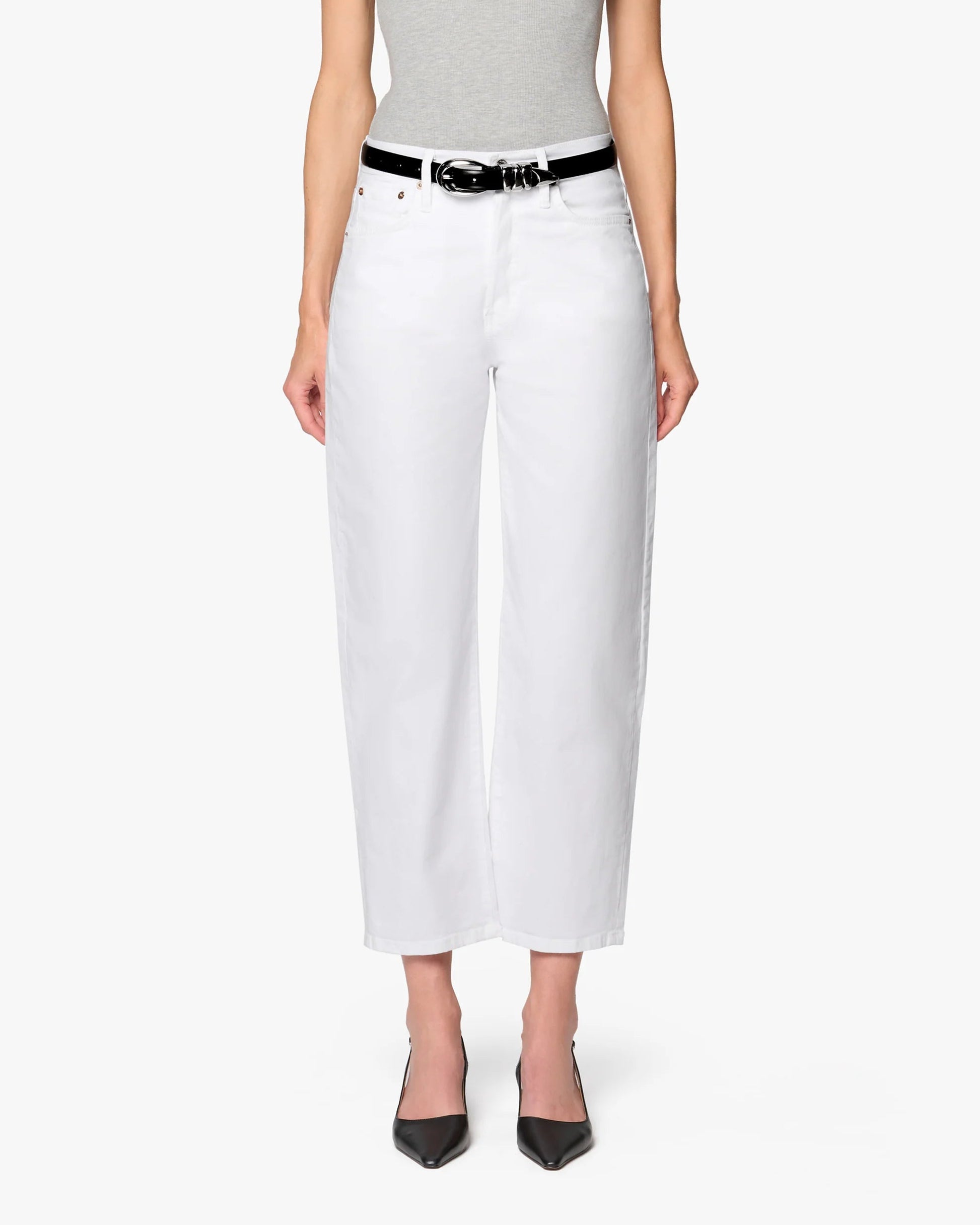 A person stands facing forward against a plain white background, wearing a gray sleeveless top, Betro Simone's Ellen Bow Leg Pant in white with a black belt, and black pointed-toe heels.