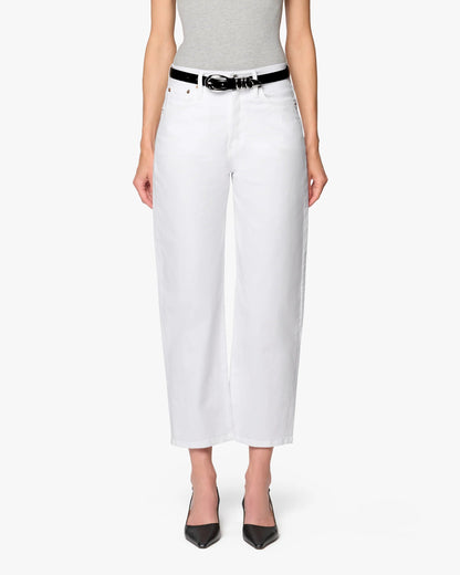 A person stands facing forward against a plain white background, wearing a gray sleeveless top, Betro Simone's Ellen Bow Leg Pant in white with a black belt, and black pointed-toe heels.