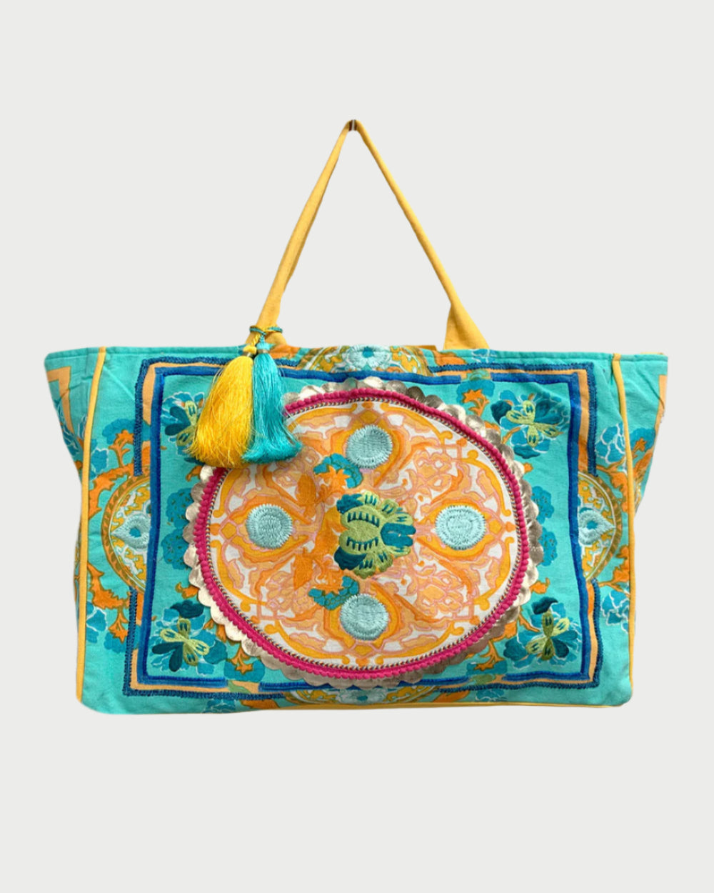 DEBBIE KATZ Boho Bag showcases artisanal embroidery in vibrant blue, orange, and yellow florals with a central circular motif and two tassels on one handle, ideal for a chic beach day.