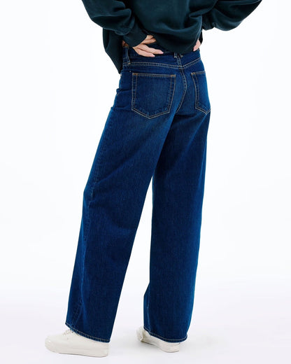 Person wearing a dark blue hoodie and jeans on a white background