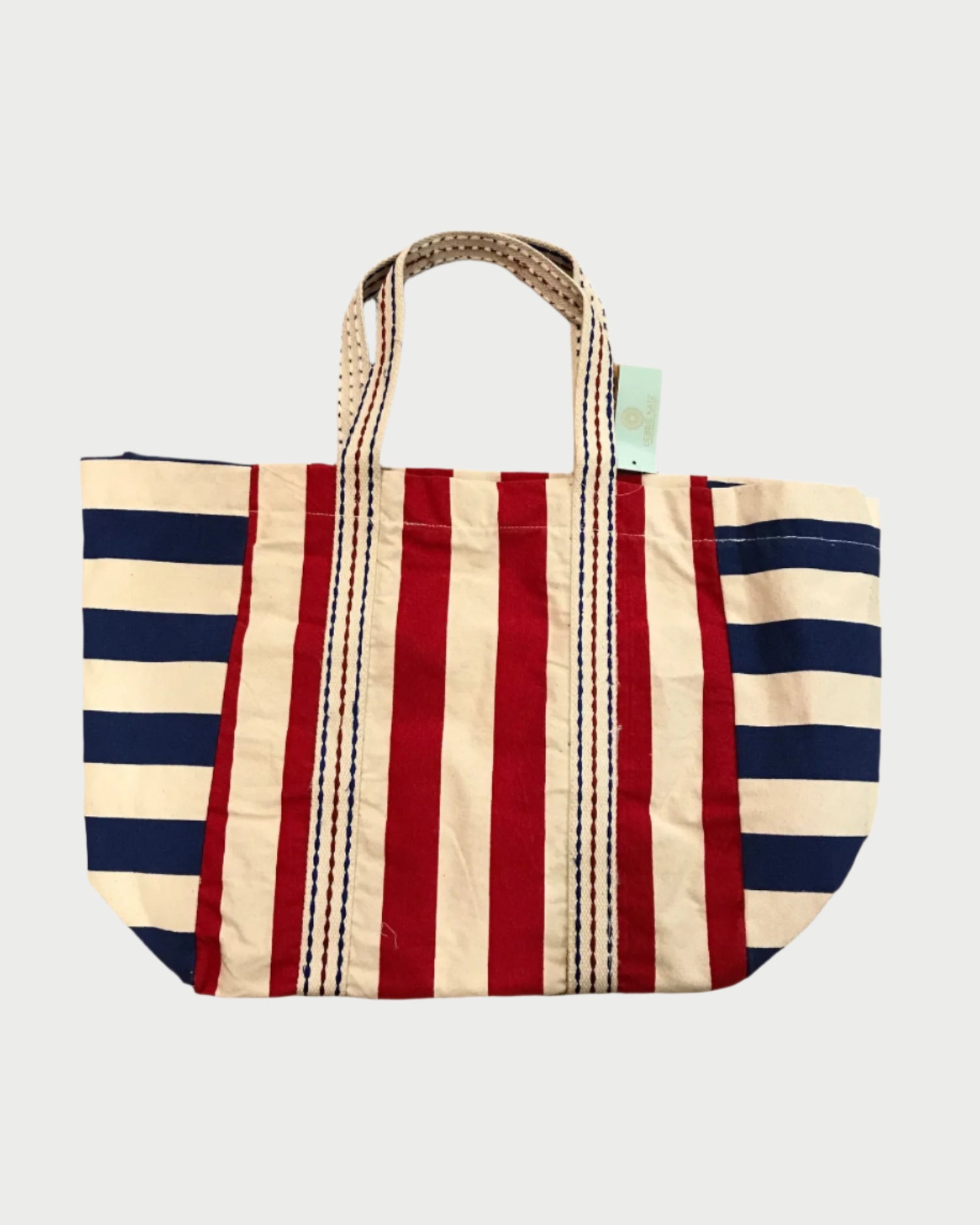 The DEBBIE KATZ Cabana Beach Bag is an extra large canvas tote with vertical red and white stripes center, blue and white stripes on the sides, and striped handles—ideal for beach parties or summer picnics.