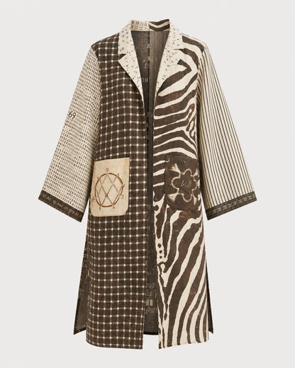 The ME369 Nova Kimono Dress by ME369 features a long silhouette with mixed-pattern brown and beige sections, highlighted by an array of graphic prints including plaid, polka dots, stripes, zebra print, and grid designs. The front is embellished with decorative square and round patches and showcases a unique illustrated lion motif for added visual flair. The dress is finished with a collar and three-quarter sleeves.