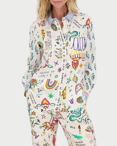 Woman wearing a colorful shirt with various designs on a white background