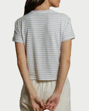 Person wearing a striped shirt and beige pants against a plain background