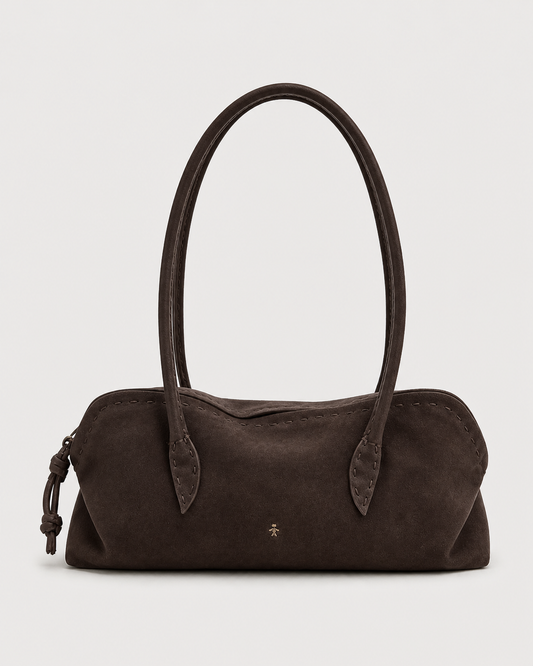 The Henry Beguelin Suede Bolla Bassa Bag features dark brown suede, two rounded top handles, subtle stitching that highlights Italian craftsmanship, a small gold emblem at the center, and a distinctive knotted accent on one side—an understated accessory embodying quiet luxury from Henry Beguelin, presented against a plain white background.