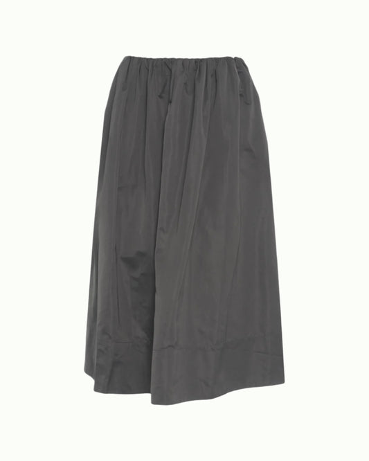 The Miss Skirt by Herskind is a loose-fitting, dark gray midi skirt featuring an elastic waistband, slightly flared silhouette, and lightweight, subtly shiny fabric for effortless style.
