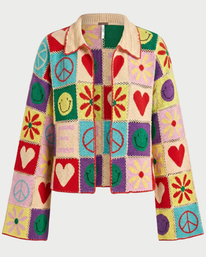 The ME369 Miami Crochet Cardigan by ME369 features vibrant granny-square patchwork with peace signs, smiley faces, hearts, and flowers in bold red, yellow, pink, green, blue, and purple for a fun retro-inspired look.