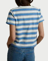 Person wearing a striped shirt and blue jeans standing against a plain background