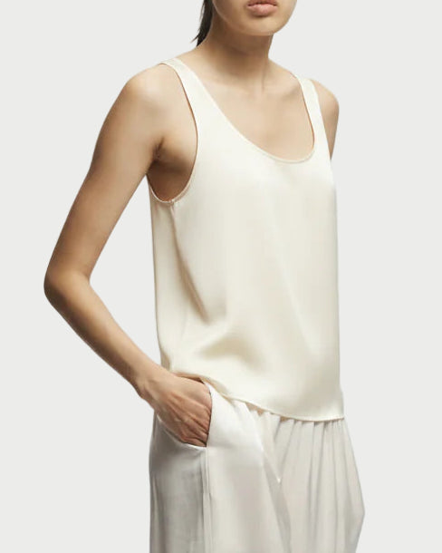 Person wearing a white sleeveless top and wide-leg pants on a white background