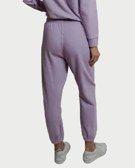 Person wearing a lavender tracksuit against a plain background