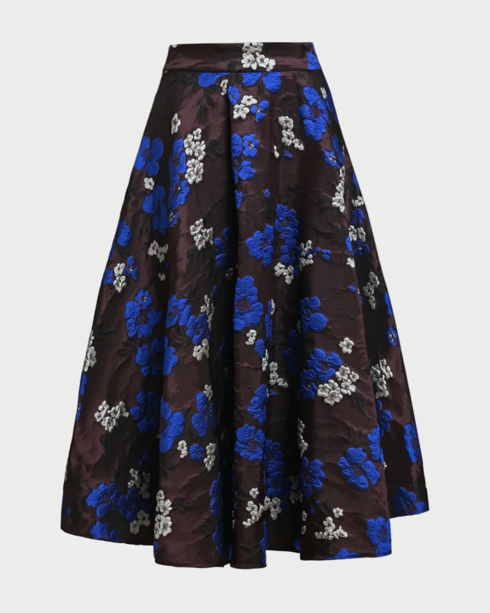 A high-waisted, A-line midi skirt in a dark brown brocade fabric with a vibrant blue and white floral jacquard pattern, shown against a plain light gray background.
