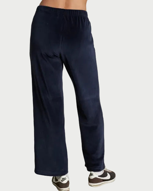Navy blue sweatpants worn by a person on a plain background