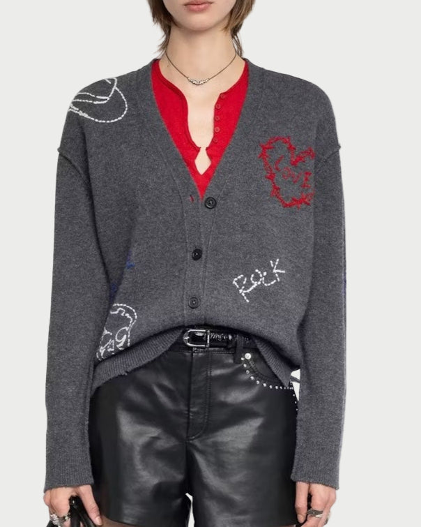 Person wearing a gray cardigan with red accents, black leather shorts, and black boots on a white background.