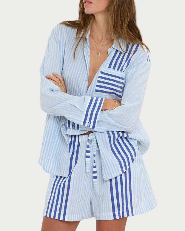 Woman wearing a blue and white striped outfit against a plain background