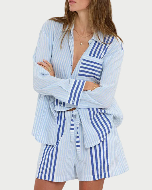 Woman wearing a blue and white striped outfit against a plain background