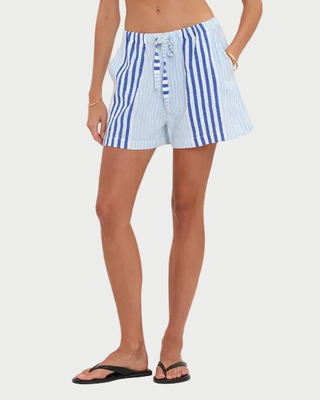 Woman wearing a strapless top and striped shorts on a white background