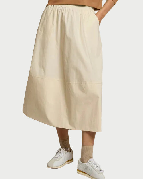 A person wears the perfectwhitetee Minka Poplin Skirt Sugar, styled with white sneakers and beige socks. Upper body is partially visible.