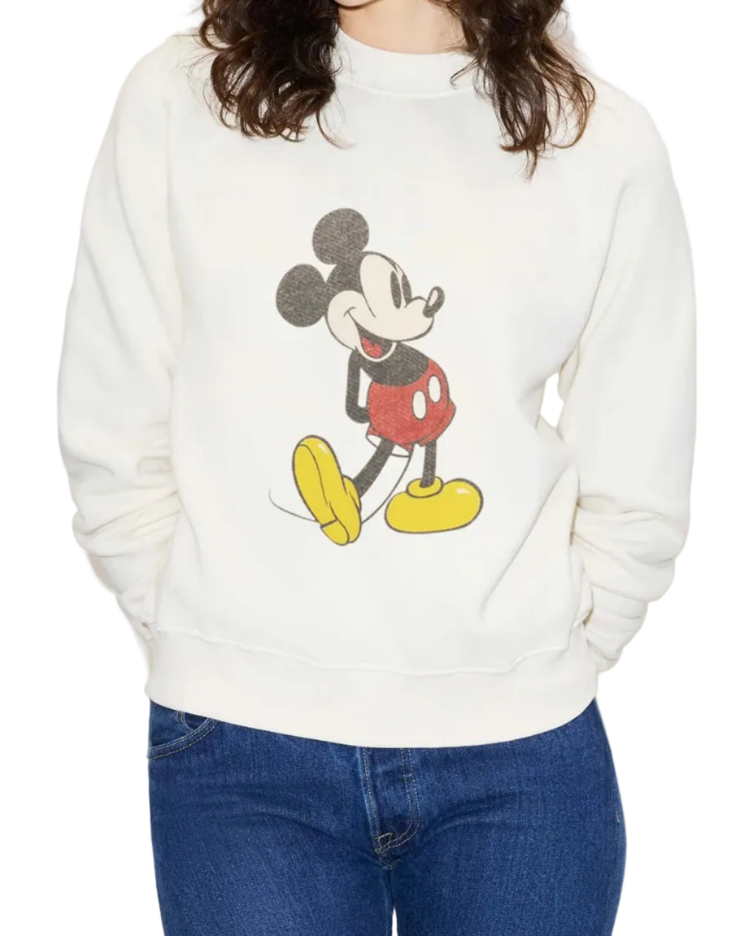 A person wears a Re/Done Mickey Mouse Classic Crewneck Sweatshirt by RE/DONE, styled with blue jeans. The person's face is not visible.