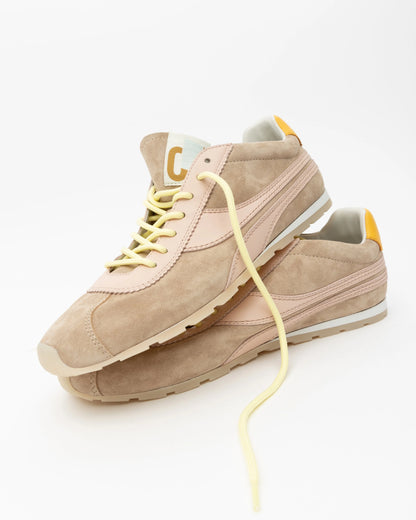 Beige sneakers with yellow laces on a white background