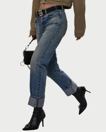 A person walks with a bag, wearing R13 Cuffed Romeo Jean Merrin Blue in a slim boyfriend fit, crafted from limited edition Italian selvedge denim.