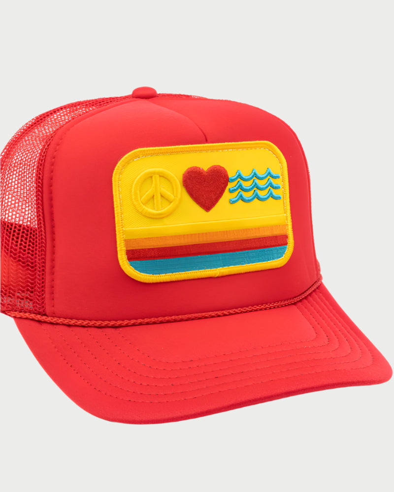 The LOCAL BEACH Peace Love Waves Trucker Hat is a red mesh cap with a yellow patch featuring a peace symbol, heart, and blue waves. Orange, red, and blue stripes run beneath the icons, perfect for embracing the "Peace Love & Waves" vibe at your local beach.