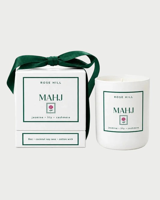 Rose Hill Mahj candle in a white vessel beside its green-ribbon gift box, with lily, jasmine and cashmere scent notes