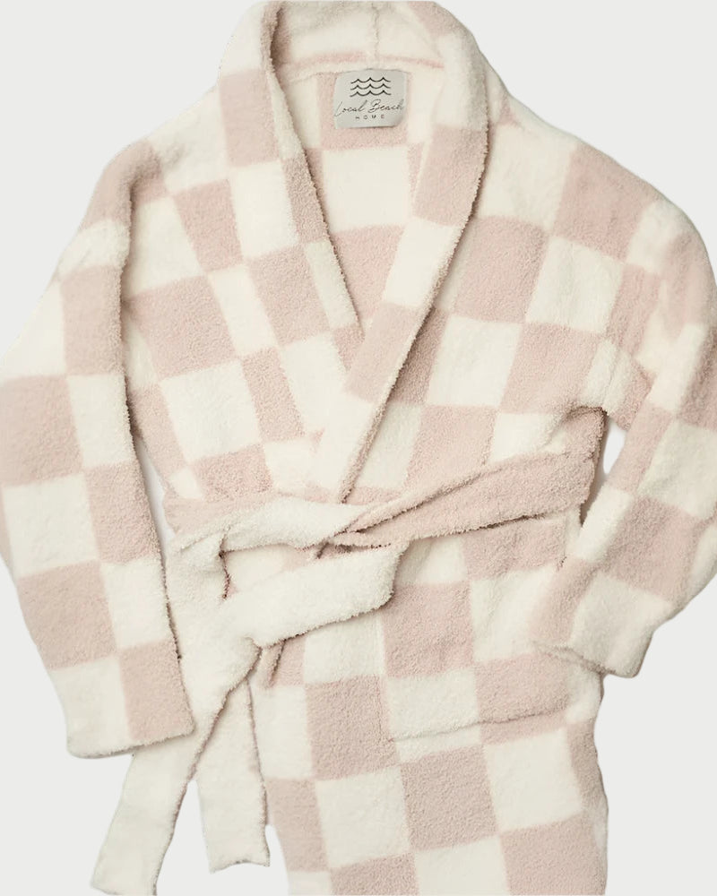 Wrap yourself in the luxury of the Luxe Robe by LOCAL BEACH, crafted from plush microfiber with a soft, fluffy texture. This robe features a pink and white checkered pattern, complemented by a shawl collar and matching belt, offering the ultimate feather knit design for an exceptionally comfortable lounging experience.
