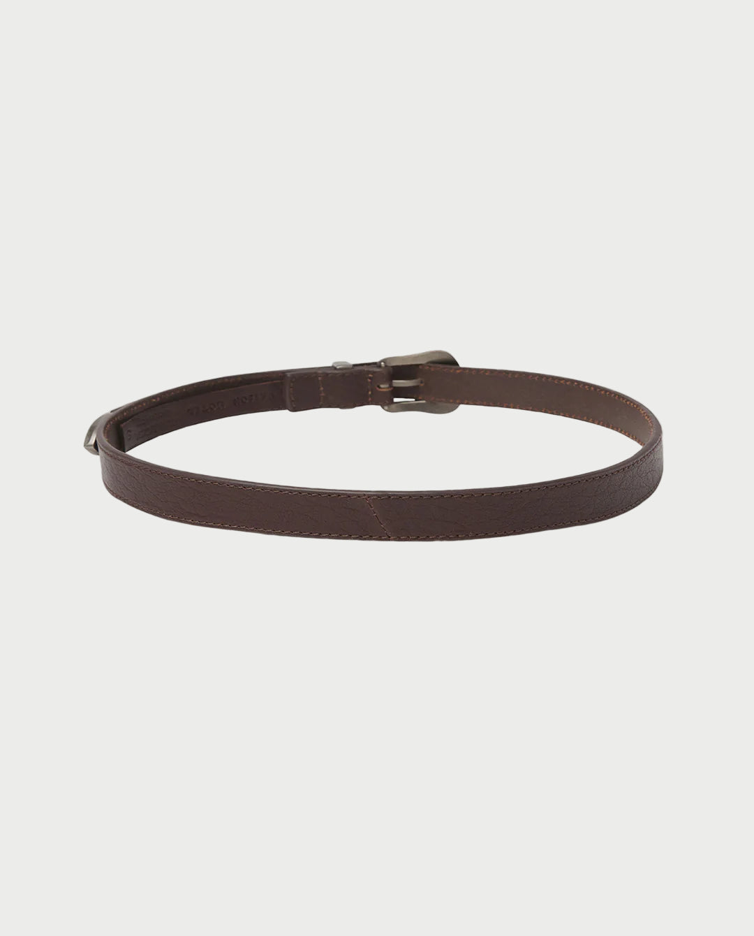 The Maison Hotel Western Dakota Belt by Maison Hotel, a brown leather belt with an antique silver buckle, is displayed in a circular shape on a plain white background.