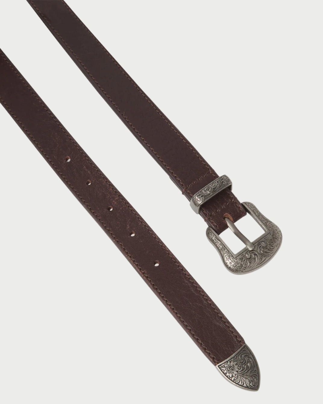 Brown leather belt with silver buckle on a light gray background