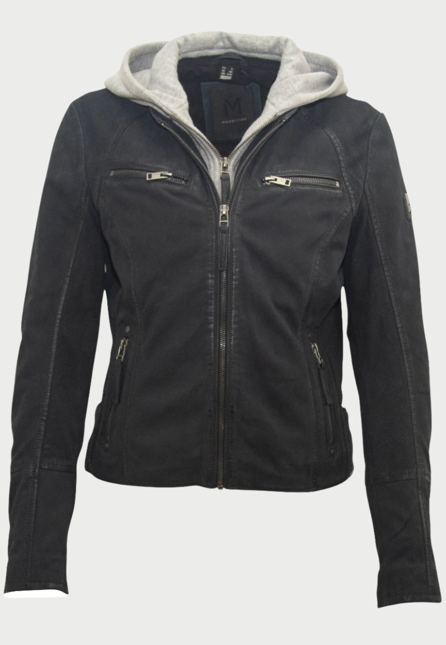 The Soft Nubuck Leather Jacket by Mauritius is a black nubuck leather moto jacket with a gray removable hoodie. It features zippers on the front, chest pockets, side pockets, and has a badge on the left sleeve.