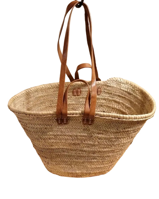 The WEST X WEST Straw Tote by West X West features two long brown leather handles and a handwoven straw design, making it an eco-friendly choice for daily use. Shown against a white background.