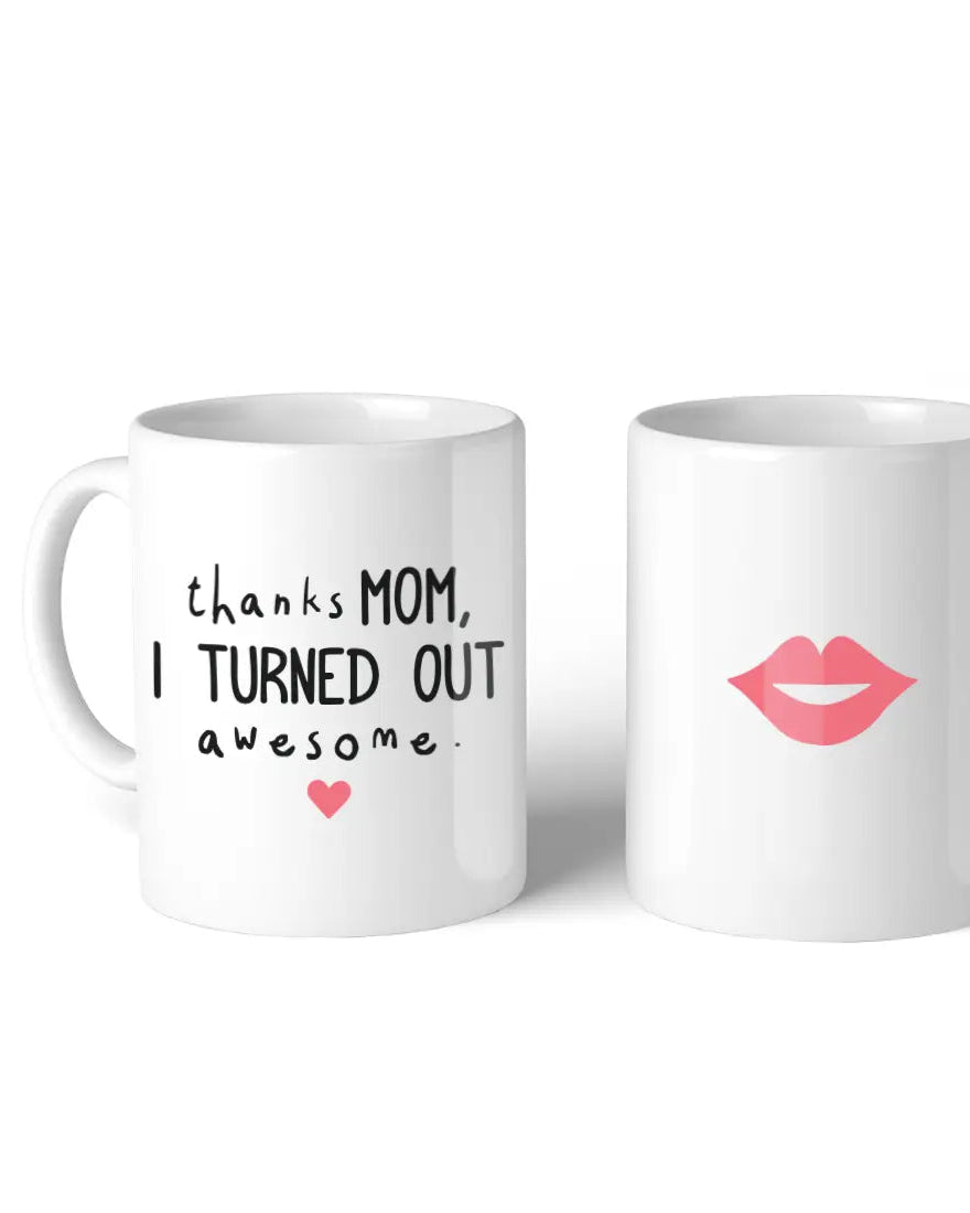 Two white ceramic mugs by 365 Printing Inc are shown. The 11oz "Thanks Mom, I Turned Out Awesome" mug features a pink heart, while the other displays pink lips. Both are made in the USA and set against a plain white background.