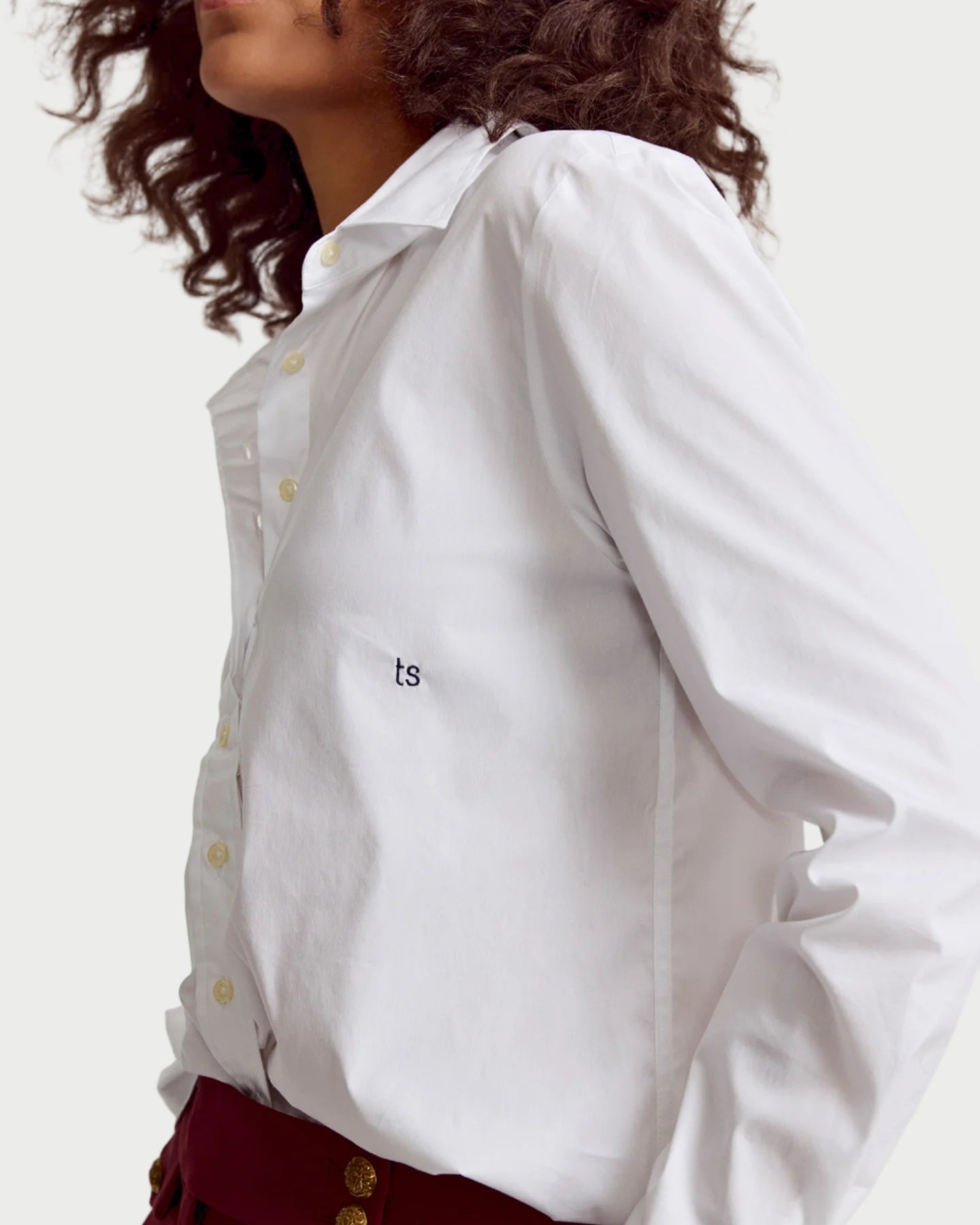 White shirt with a small logo on a plain background