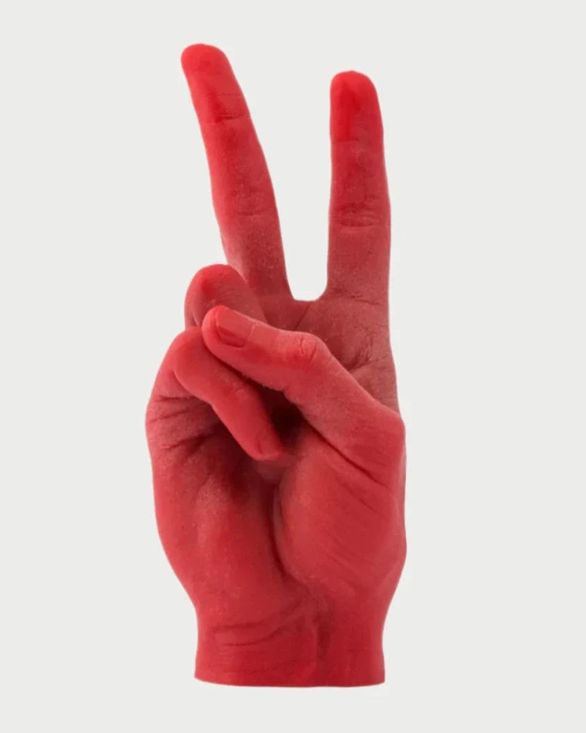 The 54° Celsius Candle Hand Victory "Peace" is a handmade, life-sized red candle shaped like a human hand making a peace sign. With two wicks at the tips of each finger forming the V shape, set against a white background, it beautifully highlights the intricate details—perfect for Spring decor.