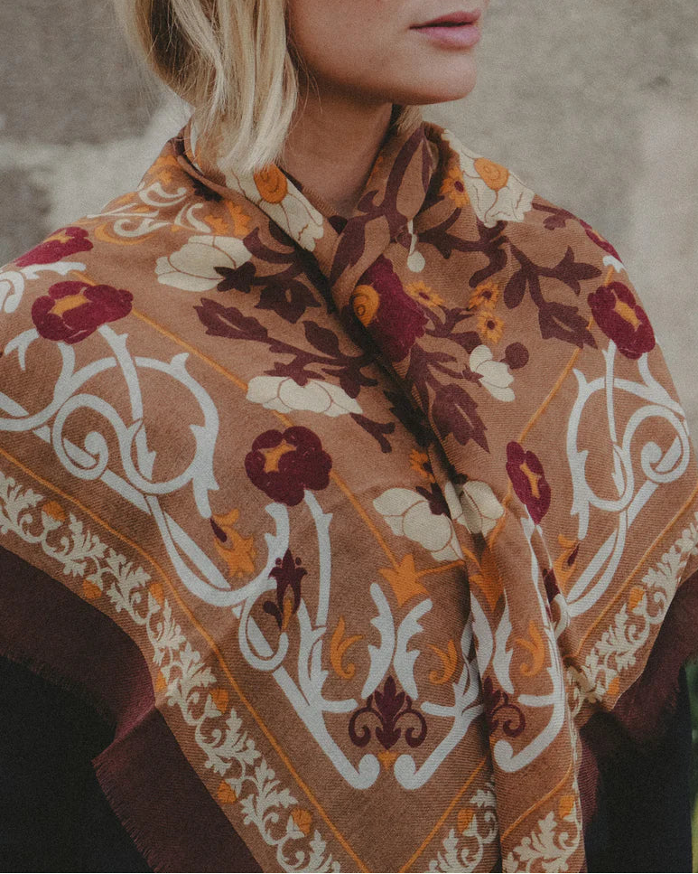 Woman wearing a patterned shawl with a neutral background