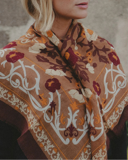 Woman wearing a patterned shawl with a neutral background